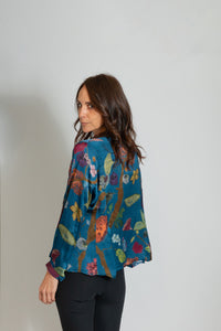 Blue funky button down blouse with long sleeves and fun floral print made of easy care cupro and imported from india by women owned, family run, line Yavi