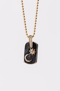 Miles McNeel Night Sky fine jewelry 14k Yellow Gold Dog Tag Pendant featuring White Diamond Bale and embossed crescent moon and star on blackened concrete