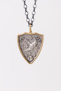 Erica Molinari two-tone, mixed metal, double-sided pendant with 18K Gold and Sterling Silver, embossed Sparrow and floral detailing on the front, with the italian phrase for "the eyes are the windows of the soul" on the back
