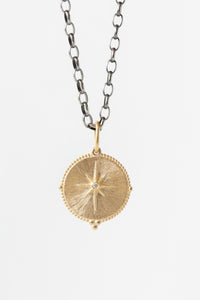 Erica Molinari round 14k gold and white diamond pendant featuring the north star on the front, and "che cazzo" engraving on the back