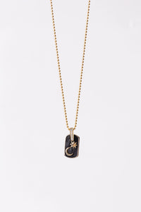 Miles McNeel Night Sky fine jewelry 14k Yellow Gold Dog Tag Pendant featuring White Diamond Bale and embossed crescent moon and star on blackened concrete